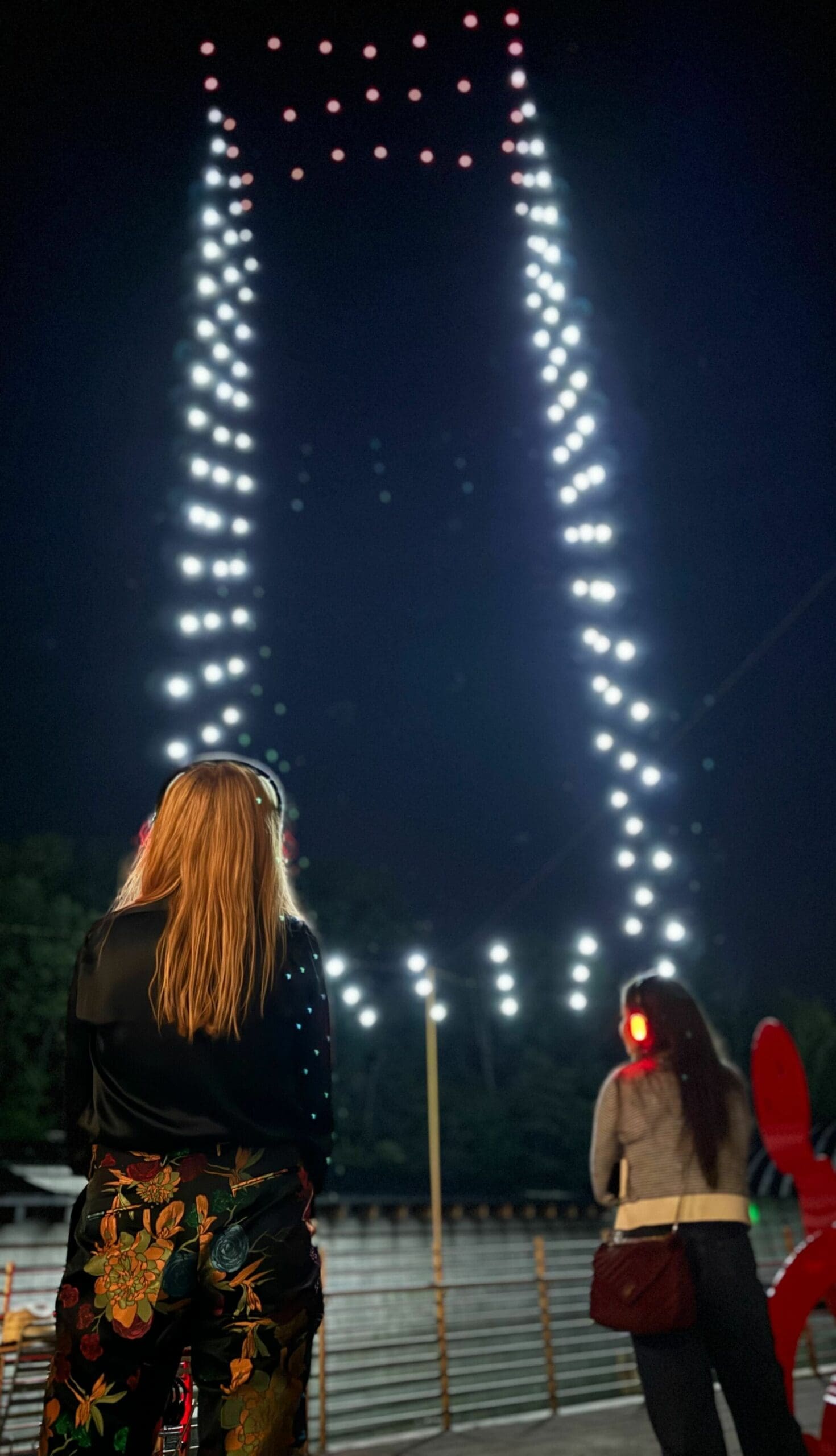 A photo of Jewel from behind as the sky story plays out brightly in front of her.